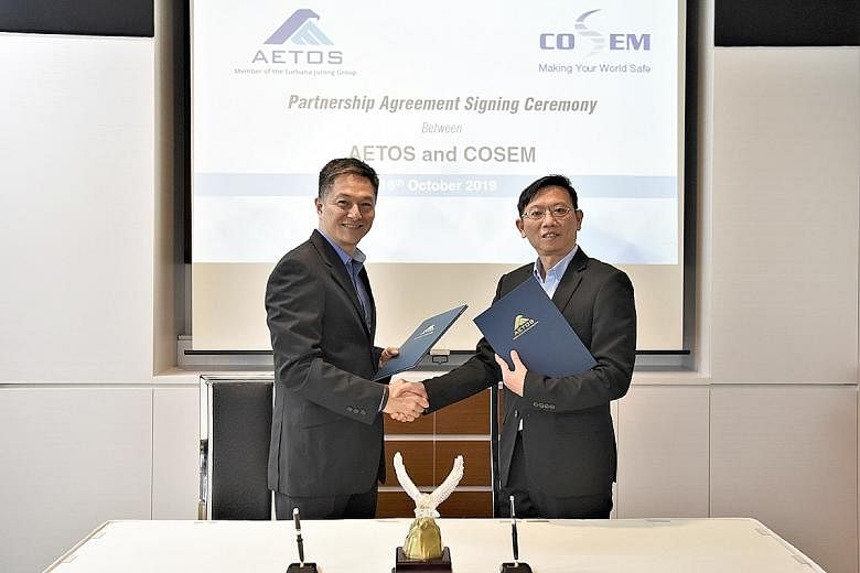 Aetos chief executive Alfred Fox (far left) and Cosem Safety & Security Services chief executive Ng Chee Kiang signed a memorandum of understanding last month. The tie-up between the two firms aims to tackle the manpower crunch in the safety and secu