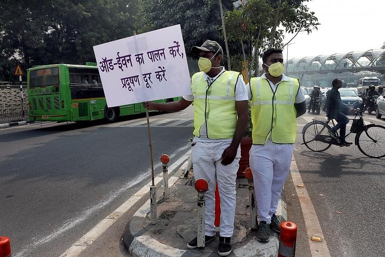 Indian civil defence volunteers holding placards in Hindi which read "Follow the odd and even scheme and make Delhi pollution free" yesterday - the first day of the implementation of the city's odd-even scheme for vehicles.