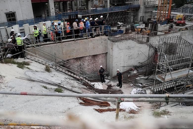 Police officers, with the body of the dead worker (foreground, covered by white sheet), at the work site in Novena yesterday. The Ministry of Manpower said the jib, or horizontal beam, of a tower crane had failed during a lifting operation. The polic