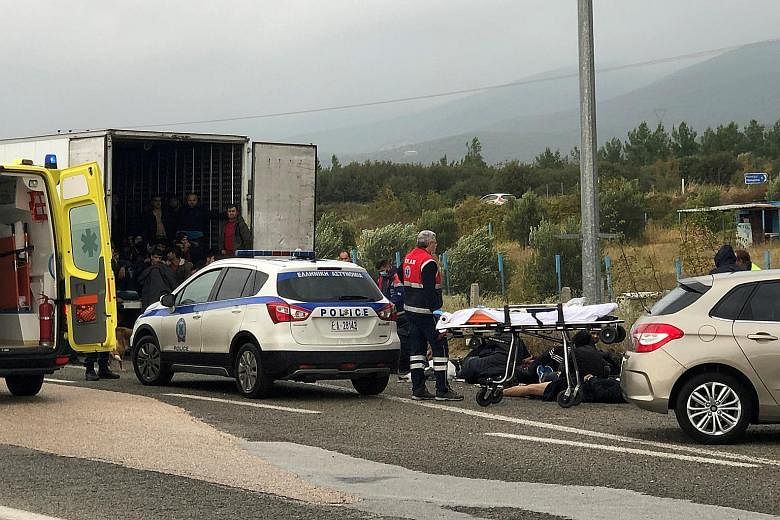 Some of the 41 migrants lying on the road while others remained inside the refrigerated truck during a routine police check near Xanthi city in Greece on Monday. Police arrested the driver and took him and the migrants to a nearby police station for 