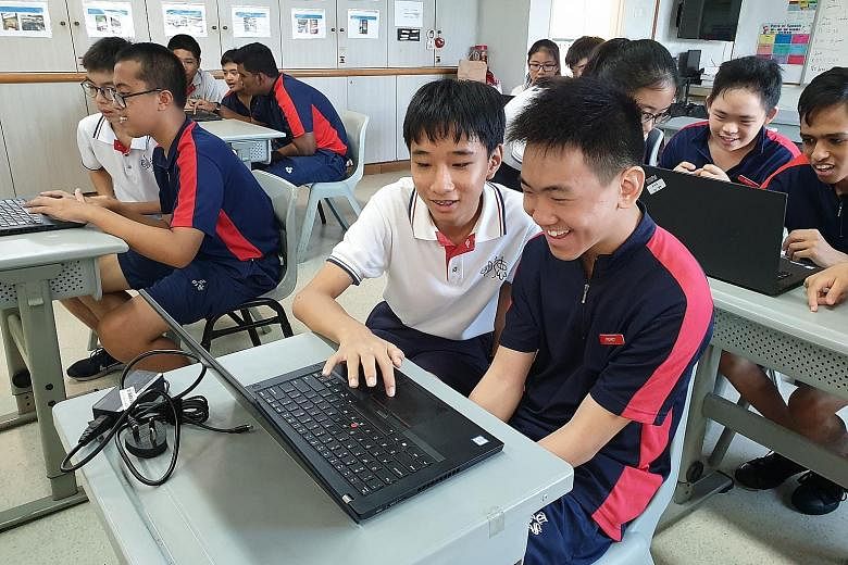 Minds Towner Gardens School student Shawn Goh (right) in a discussion with Dunman High School student Tan Qi En as they researched and designed logos using basic computer skills.