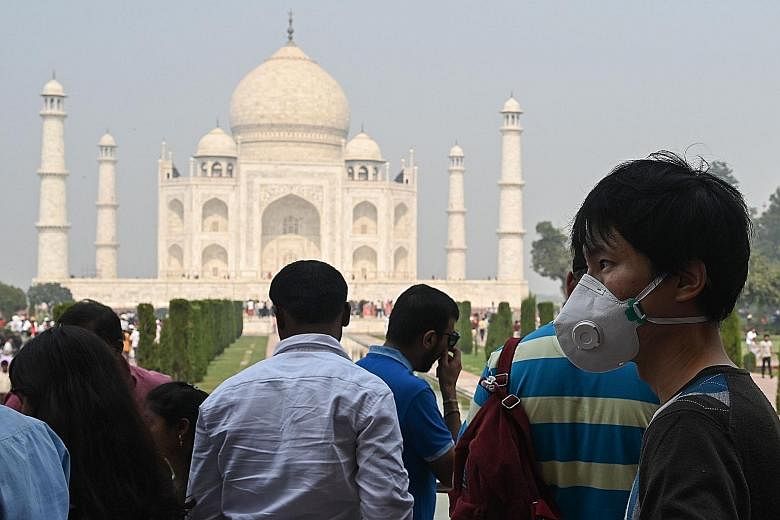 A tourist at the Taj Mahal in Agra wearing a face mask to protect against air pollution. Analysts say India's plans to tackle the problem suffer from lackadaisical enforcement and lack of coordination. There are few penalties, and little transparency