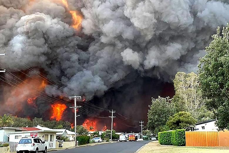 Flames from an out-of-control bush fire as seen from a nearby residential area in Harrington, some 335km north-east of Sydney. Australian firefighters warned that they were in "uncharted territory" as they struggled to contain dozens of out-of-contro
