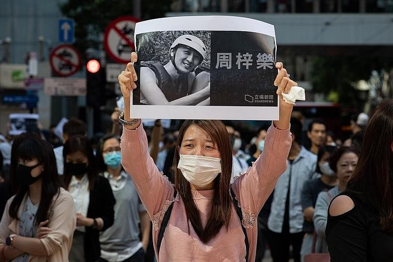 Protesters taking part in a flash mob rally in Hong Kong last Friday. They were mourning the death of Mr Chow Tsz Lok, a student who died following clashes between the police and protesters last Monday.