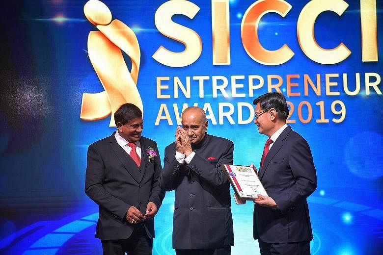 Mr Ameerali R. Jumabhoy (centre) receiving the Singapore Indian Chamber of Commerce and Industry (SICCI) Lifetime Achievement Award from Deputy Prime Minister Heng Swee Keat in the presence of SICCI chairman T. Chandroo at a dinner to mark the SICCI'