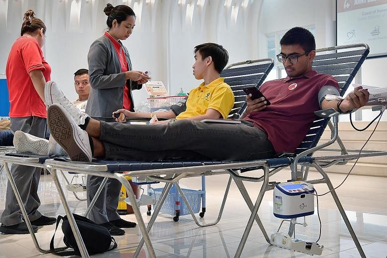 Mr Vamsi Krishna, 21, and student Bowen Ong (in yellow), 18, were among about 200 people who donated blood at the event held jointly by Heart of God Church, Khalid Mosque, Geylang United Temple and Nanyang Leow-Sih Association yesterday.