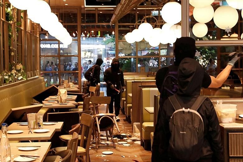 Protesters vandalising a restaurant during an anti-government demonstration at a shopping mall in Tsuen Wan, Hong Kong, yesterday. Some protesters had trashed several shops in Sha Tin linked to the Maxim Catering Group, including a Starbucks and a Ma