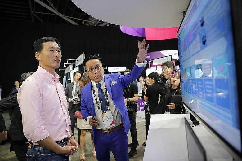 Education Minister Ong Ye Kung visiting ST Engineering's booth at the Singapore FinTech Festival yesterday. With him was Mr Tan Boon Leong, a senior system consultant (data analytics) from ST Engineering.