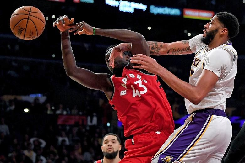 Toronto's Pascal Siakam (left) fighting for a rebound with Anthony Davis of the LA Lakers during their NBA game at the Staples Centre in Los Angeles on Sunday. PHOTO: AGENCE FRANCE-PRESSE