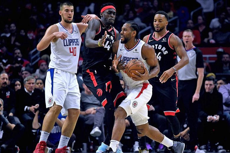 LA Clippers' Kawhi Leonard finding his path to the basket blocked by Toronto's Pascal Siakam during their NBA game on Monday. The Clippers won 98-88. PHOTO: AGENCE FRANCE-PRESSE