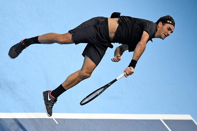 Swiss legend Roger Federer serving to Italy's Matteo Berrettini in their ATP Finals group-stage match yesterday. He won 7-6 (7-2), 6-3 but will likely have to beat Novak Djokovic tomorrow to seal a place in the semi-finals. PHOTO: REUTERS