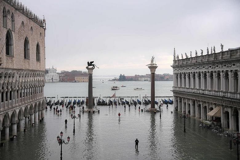The flooded St Mark's Square, with the Doge's Palace (left), the winged bronze statue of the Lion of St Mark (centre left) and the Venetian lagoon after an exceptional overnight "acqua alta", or high waters, peaked at 1.87m in Venice yesterday. Only 