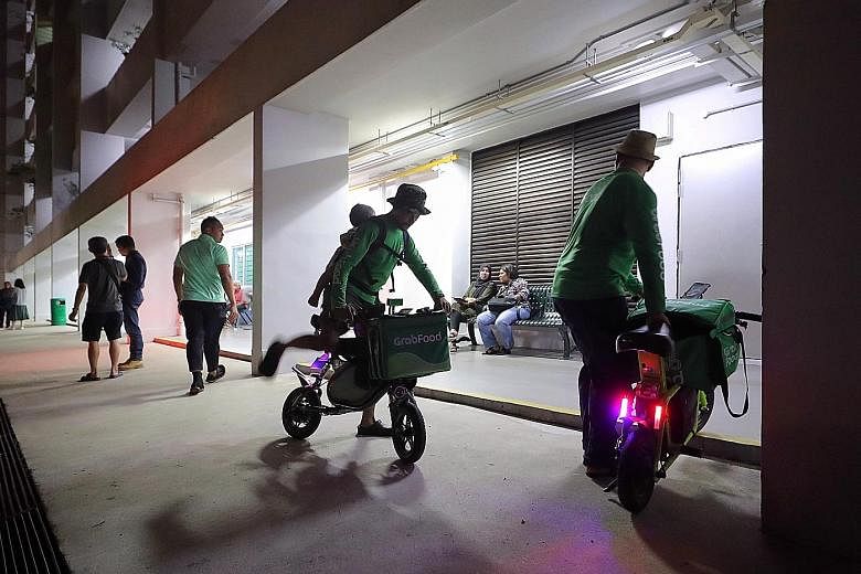 Two food delivery riders spoke to volunteers outside the Meet-the-People Session at Prime Minister Lee Hsien Loong's Teck Ghee ward in Ang Mo Kio yesterday. They were there for about 12 minutes and did not enter the waiting room. ST PHOTO: GAVIN FOO