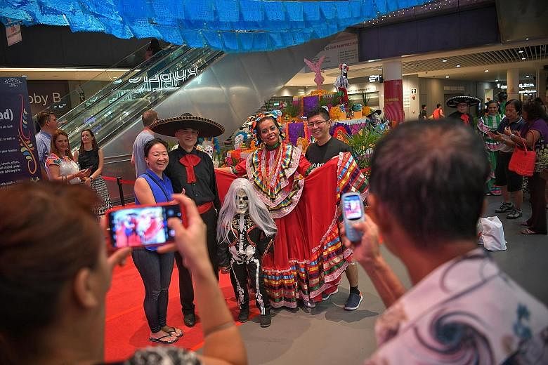 Costumed performers took Day of the Dead festivities into the heartland on Tuesday, with the launch of celebrations for the Mexican festival, Dia de Muertos, at Our Tampines Hub. Visitors were treated to food and musical performances, and viewed a ph