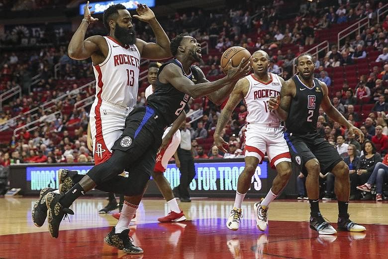 Los Angeles Clippers guard Patrick Beverley trying to score after getting past Houston Rockets guard James Harden during their NBA game at the Toyota Centre on Wednesday night. The Rockets won 102-93 to improve to 8-3. PHOTO: REUTERS