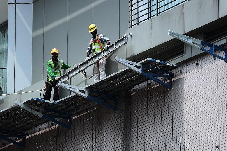 Workers using safety harnesses while working at a height. Last year, eight workers died as a result of a fall from height, down from 24 in 2009. ST PHOTO: KELVIN CHNG