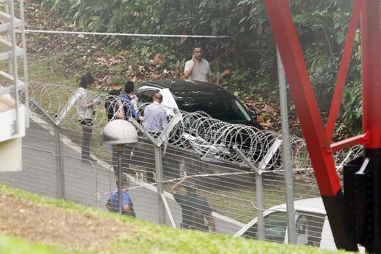 The police said they were alerted to the two cases along Lorong Sesuai at 6.42am. The boy, five, was found motionless in a car while the woman, 41, was found lying motionless nearby. PHOTO: SHIN MIN DAILY NEWS
