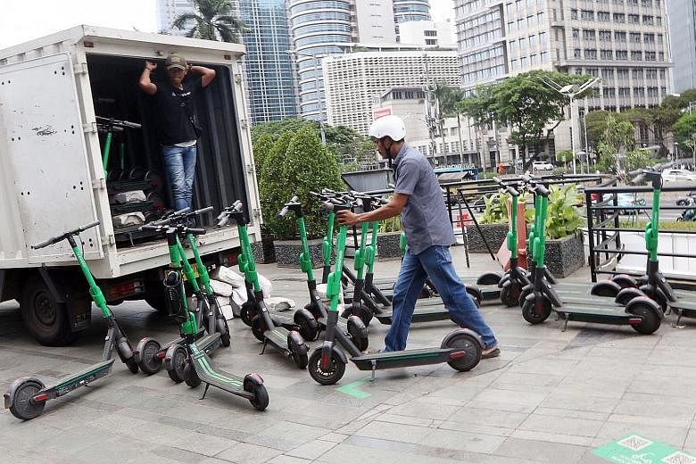 Workers loading GrabWheels e-scooters in Senayan, Jakarta onto a truck on Thursday. Stricter regulations on their use are slated to be out next month. PHOTO: JAKARTA POST/ASIA NEWS NETWORK