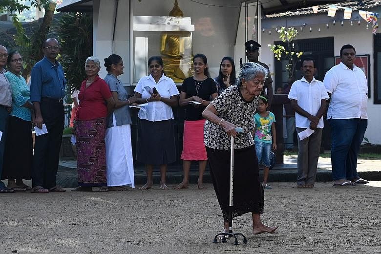 Voters lining up at a polling station in Colombo yesterday.