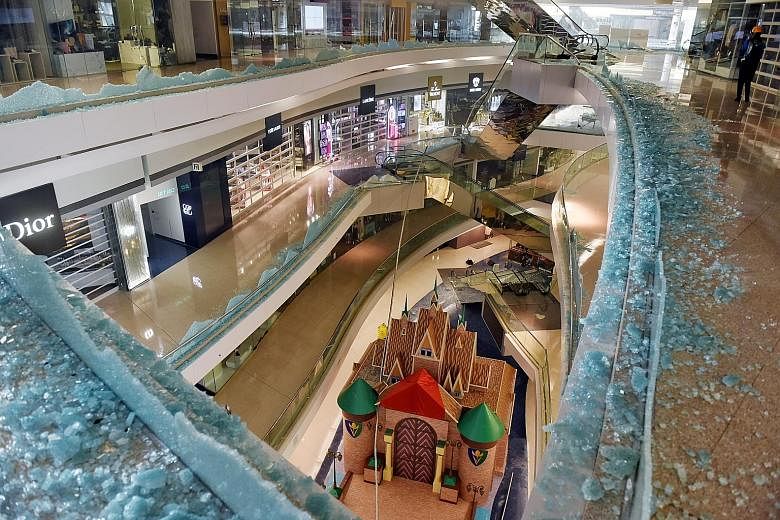 The Festival Walk shopping mall (left) was among businesses vandalised during protests in Kowloon Tong, Hong Kong, last Wednesday. On Tuesday, some stores in the city, such as this (centre), were set on fire. Others, like Starbucks, were hit after a 