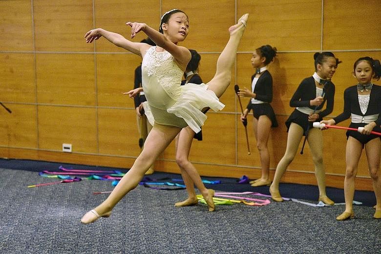 Lyrical dancer Chloe Chua, 13, from CHIJ St Theresa's Convent, performs to the song Rewrite The Stars as gymnasts from Releve Rhythmic Gymnastics Academy wait in the background. 
