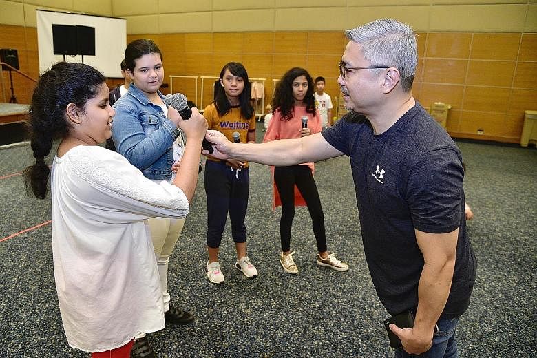 Music director George Leong shares tips on microphone handling techniques with (from left) Jyotsnaa Jayashanker, 11, Scarlett Summers 11, Danielle Marie Ramas Soriano, 13, and Simran Kaur Sidhu, 10. 
