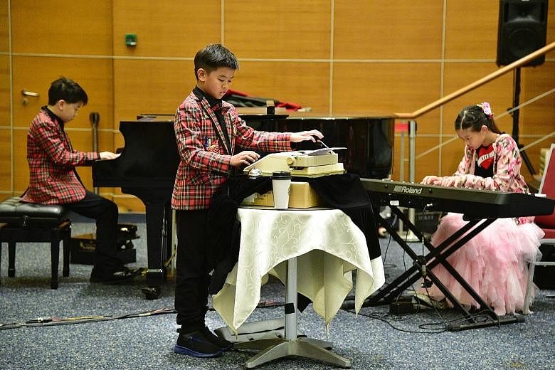 Performers from Thailand (from left) Krittaphas Kunkhongkaphan, 11, Tanasorn Pholtape, 10, and Sirima Pholtape, 12, perform on a piano, a typewriter and a keyboard for their take on The Typewriter, an original composition by American composer Leroy Anders