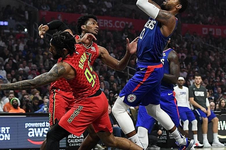 LA Clippers forward Paul George making a shot over Atlanta guard DeAndre' Bembry and centre Damian Jones at Staples Centre on Saturday. Despite the Clippers missing several men, including Kawhi Leonard, the Hawks had no answer to George, who had LA t