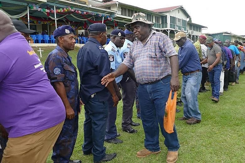 Former Bougainville Revolutionary Army fighters greeting Papua New Guinea policemen on Nov 6 in Kokopo, East New Britain, at a reconciliation ceremony in a symbolic outpouring of forgiveness between "Melanesian brothers" ahead of a historical independence
