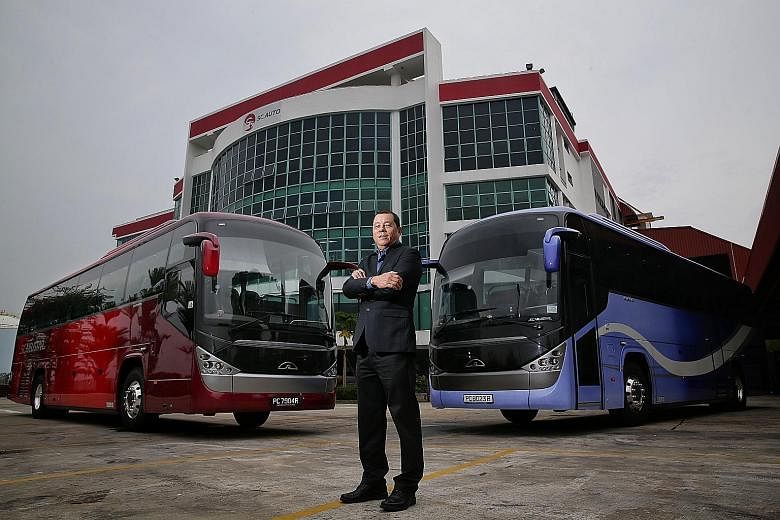 SC Auto chairman Tan Siow Chua with SC Neustar buses, the first to be completely built and designed in Singapore, at SC Auto's Senoko premises. The firm is able to deliver around 900 buses a year from its factories in Senoko and Yangon, Myanmar. Mr T