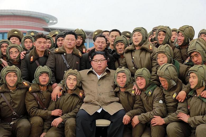 An undated photo released by the Korean Central News Agency showing North Korean leader Kim Jong Un with members of the Air and Anti-Aircraft Force of the Korean People's Army. PHOTO: