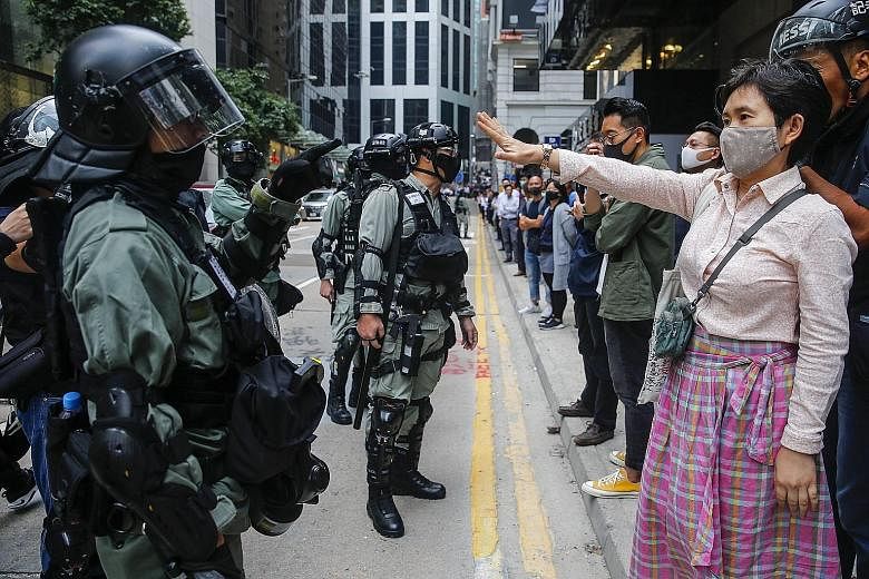 Mr Chris Tang Ping Keung's (above) appointment comes after the retirement of Mr Stephen Lo Wai Chung from the position. Left: Protesters and police officers facing off during an anti-government protest in Hong Kong yesterday. Right: People cleaning u