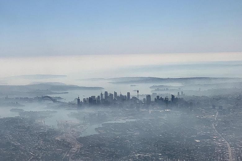 Sydney's skyline obscured by haze yesterday, as seen from a plane. Much of the smoke is being blown from a huge bush fire spreading across two national parks that is just 100km north-west of central Sydney at its closest point.
