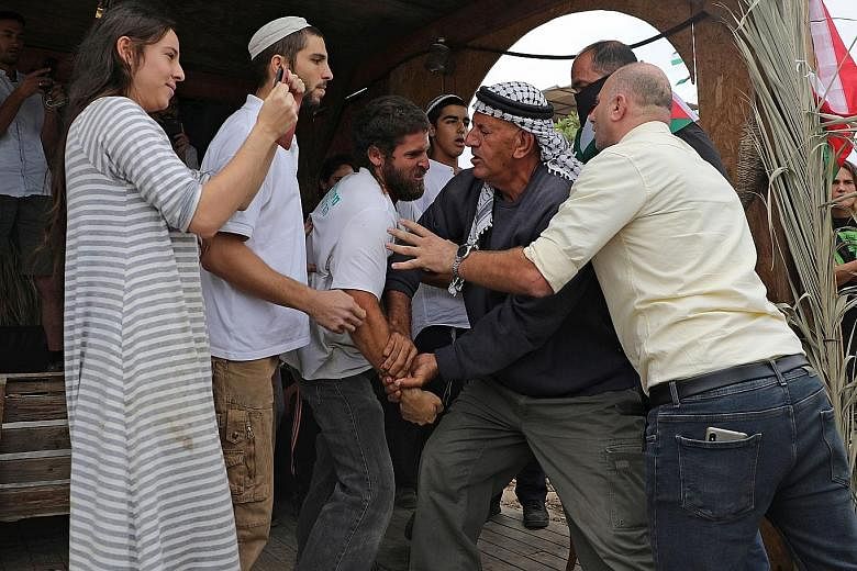 Israelis clashing with Palestinians on Oct 26 at a protest against the setting-up of an Israeli outpost in the Jordan Valley. PHOTO: AGENCE FRANCE-PRESSE