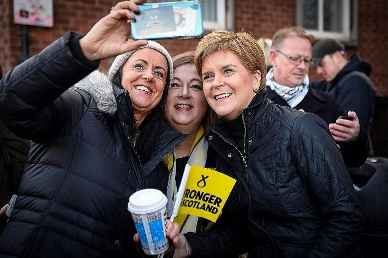 Scottish National Party (SNP) leader Nicola Sturgeon (third from far left) with supporters in Glasgow, Scotland, on Sunday. Ms Sturgeon told voters that a vote for the SNP is a vote to escape Brexit. PHOTO: AGENCE FRANCE-PRESSE