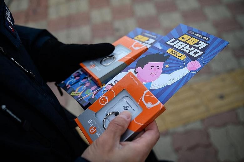 A Samsung Electronics worker holding trade union membership recruitment leaflets. For almost 50 years, the flagship subsidiary of the giant Samsung Group has avoided unionisation of its employees.