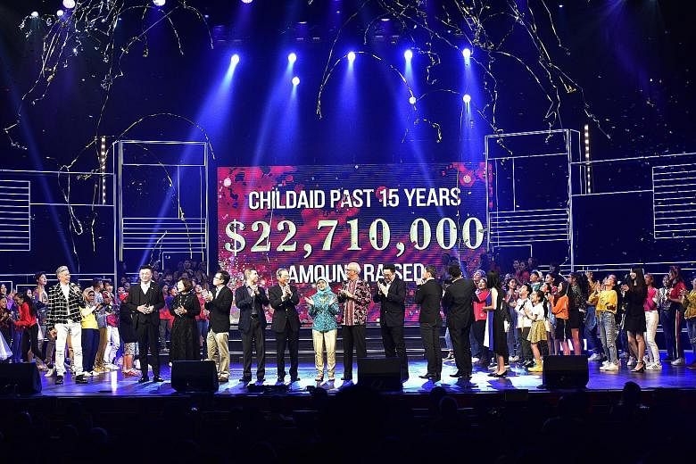 President Halimah Yacob and her husband, Mr Mohamed Abdullah Alhabshee, at the ChildAid 2019 event which raised $2.12 million for charity this year. With them on stage last night were the show's performers, its creative director Dick Lee, Singapore P