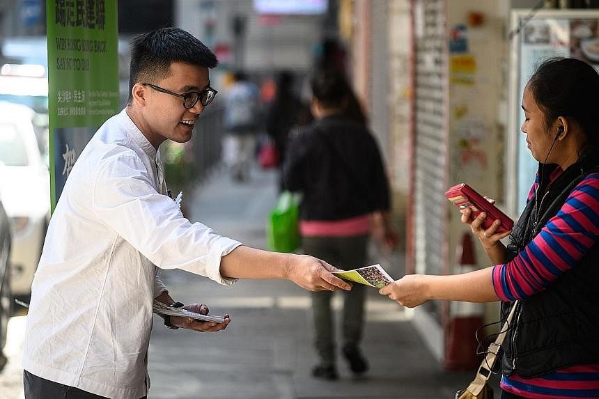 First-time candidate Kwan Siu Lun says campaigning for the district elections has been a dangerous business in the heat of the city's political crisis. Another candidate, Mr Isaac Ho, handing out leaflets to people in Tsim Sha Tsui. Mr Ho is among a 
