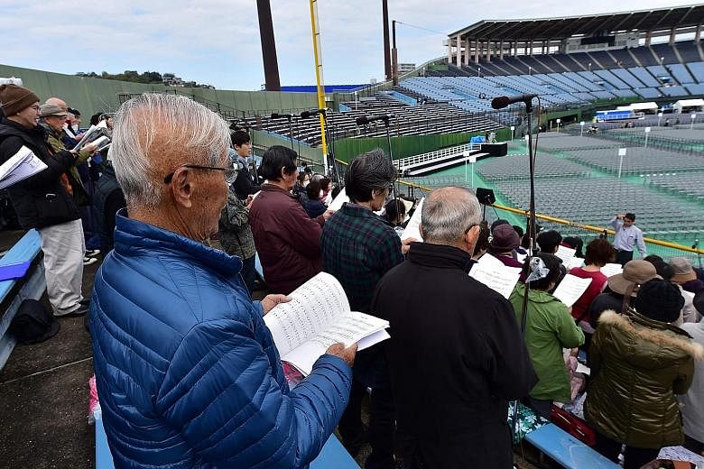 Atomic bomb survivor Kenji Hayashida (in blue jacket) attending a singing practice yesterday at Nagasaki Baseball Stadium, where Pope Francis will lead a Holy Mass today. The Pope, an anti-nuclear campaigner, will meet survivors of the World War II a
