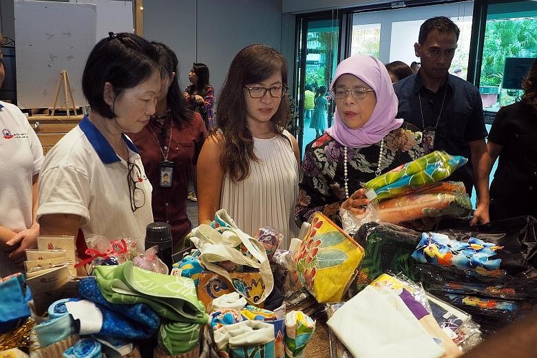 President Halimah Yacob viewing a product by Arts@Metta at i'mable Collective's gift market at the Enabling Village in Lengkok Bahru yesterday. The collective aims to be the preferred first stop for organisations keen to support the purchase of high-