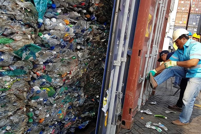 A port employee locking a container filled with waste set to be sent back to its origin country, Australia. An Australian flag protruding from a mound of plastic waste at an imported-plastic dump site in Mojokerto, East Java. The Indonesian authoriti