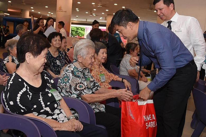 Speaker of Parliament Tan Chuan-Jin distributing food hampers to elderly beneficiaries at the launch of the 2019 Boys' Brigade Share-a-Gift charity drive at Our Tampines Hub.