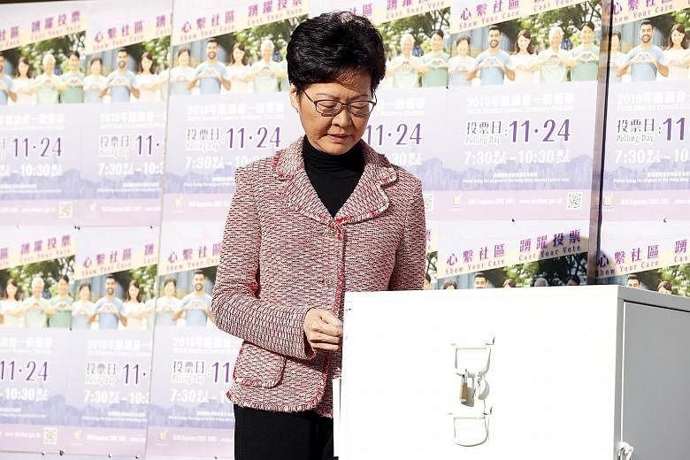 Above: People queueing to vote in district council local elections on Hong Kong Island yesterday. PHOTO: REUTERS Left: Hong Kong Chief Executive Carrie Lam casting her vote yesterday.