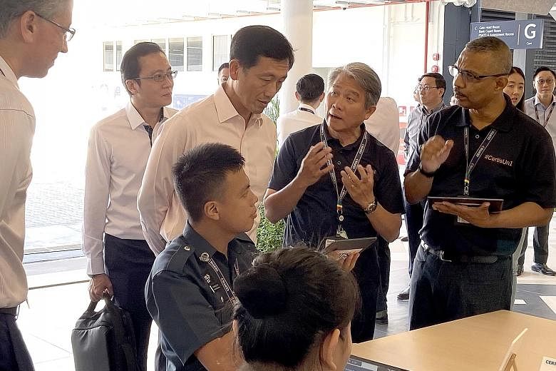 Trainers at Certis Corporate University explaining to Education Minister Ong Ye Kung, who officially launched the university yesterday, how online simulations of real-life situations can be used in timed assessments.