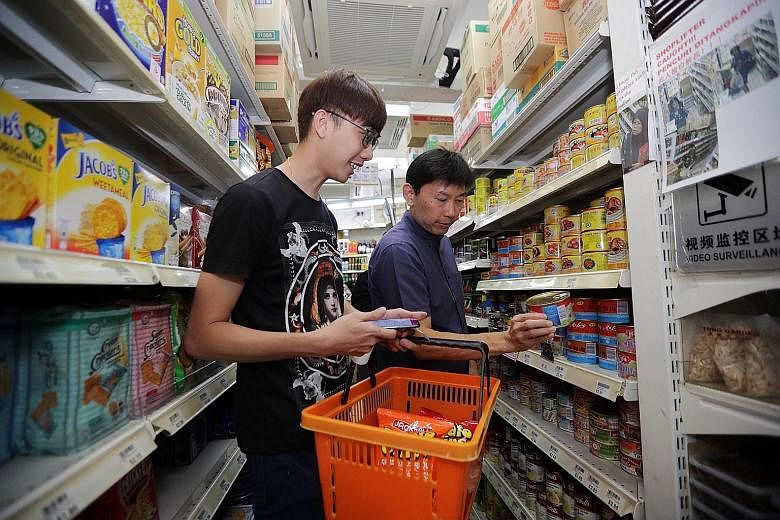 Mr Lee Jong Ren, 29, a retail sales assistant going through a shopping list with Senior Minister of State for Trade and Industry and Education Chee Hong Tat yesterday at Kim Eng Mini Supermarket in Chong Pang City. A four-year plan has been created t