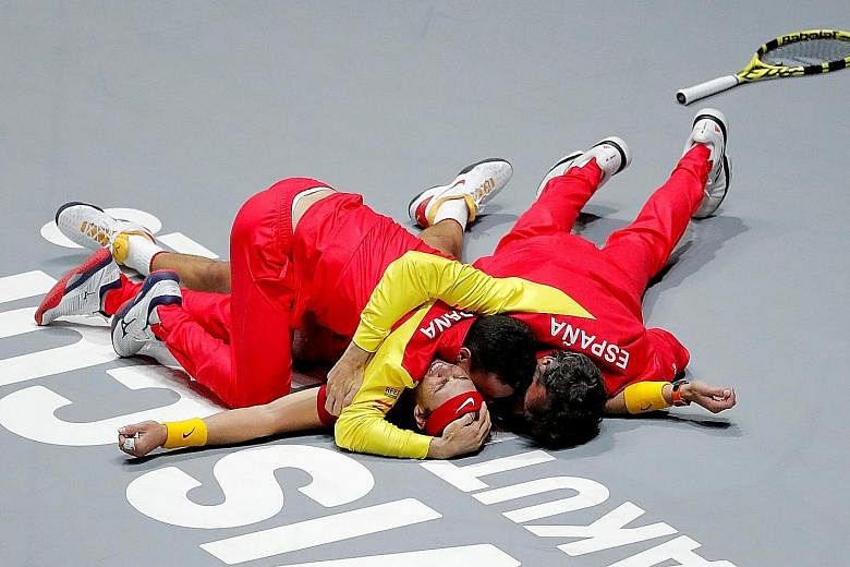 Rafael Nadal's teammates piling on him to celebrate Spain's winning point in the Davis Cup, after he beat Canada's Denis Shapovalov in Madrid on Sunday. It is the country's sixth title. PHOTO: REUTERS