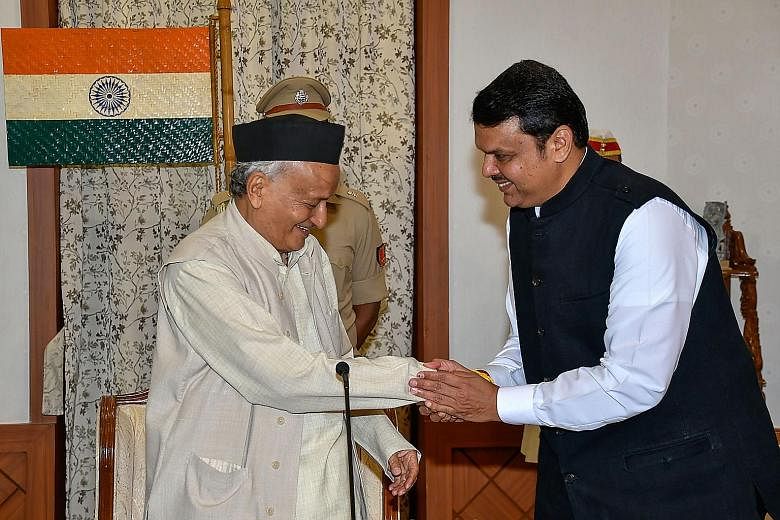 Maharashtra Governor Bhagat Singh Koshyari (left) greeting BJP's Devendra Fadnavis after his swearing-in as chief minister last Saturday. Mr Fadnavis resigned from his post yesterday.