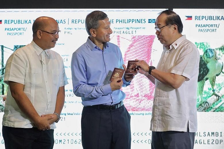 Foreign Minister Vivian Balakrishnan receiving the "passports" of the two eagles - Geothermica and Sambisig (right) - from Philippine Ambassador Joseph Del Mar Yap at Jurong Bird Park yesterday. With them is Mr Ricardo L. Calderon, Assistant Secretar