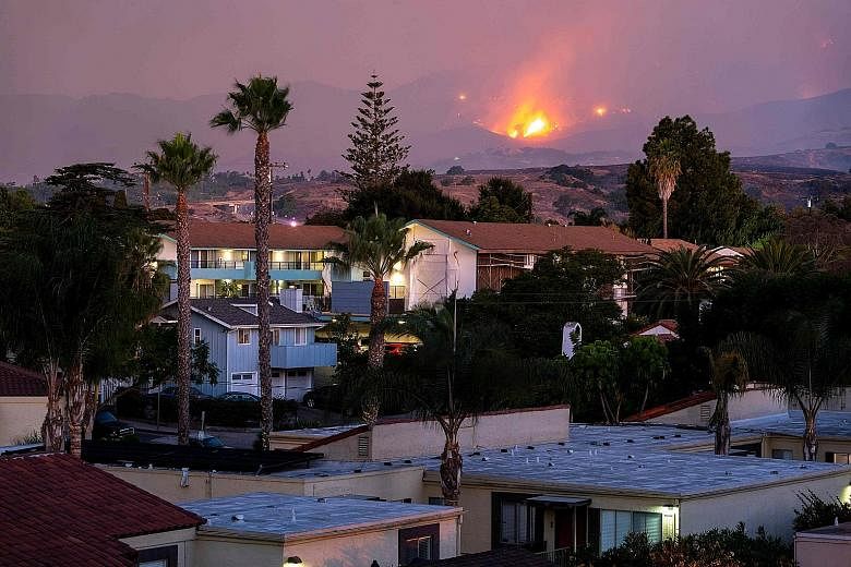 The fire burning on a hillside above houses in Santa Barbara, California, on Tuesday. The "Cave Fire" that started on Monday in Los Padres National Forest grew to nearly 1,740ha overnight. The authorities said the fire, the cause of which was still u