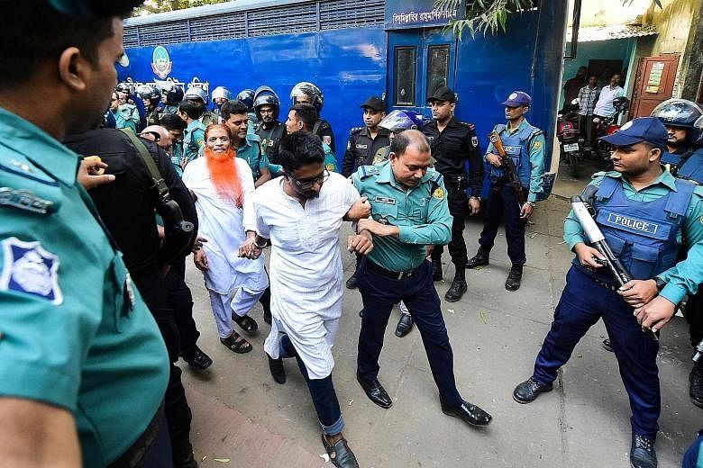 Police escorting members of an Islamist militant group, who were accused of plotting the 2016 Holey Artisan cafe attack, to a courtroom for their trial and sentencing in Dhaka yesterday. PHOTO: AGENCE FRANCE-PRESSE